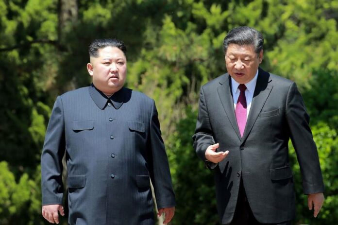 Chinese President Xi Jinping (right) walks with North Korean leader Kim Jong Un in Dalian in this May 8, 2018, photo from North Korea's official Korean Central New Agency
