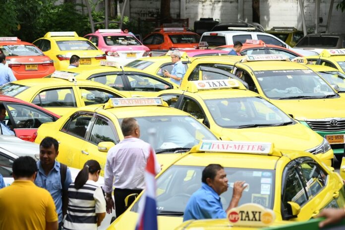 Taxi drivers park their vehicles at Bhumjaithai Party headquarters on June 24, 2019, to oppose the party's pledge to legalize online, unlicensed taxi drivers.