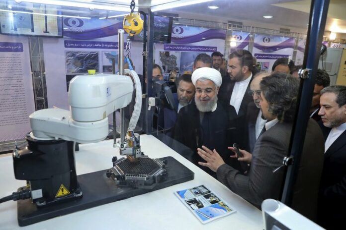 In this April 9, 2018 file photo, released by an official website of the office of the Iranian Presidency, President Hassan Rouhani listens to explanations on new nuclear achievements at a ceremony to mark
