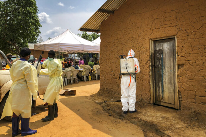 A worker from the World Health Organization (WHO) decontaminates the doorway of a house on a plot where two cases of Ebola were found, in the village of Mabalako, in eastern Congo Monday, June 17, 2019. Health officials in eastern Congo have begun offering vaccinations to all residents in the hotspot of Mabalako whereas previous efforts had only targeted known contacts or those considered to be at high risk. Photo: Al-hadji Kudra Maliro / AP