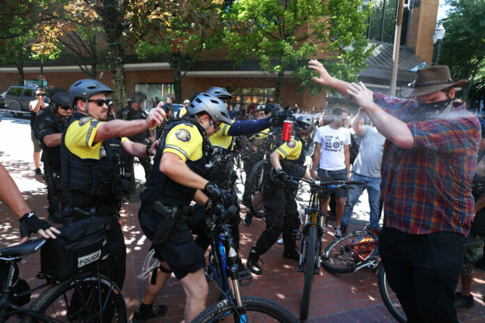 After a confrontation between authorities and protestors, police use pepper spray as multiple groups, including Rose City Antifa, the Proud Boys and others protest in downtown Portland, Ore., on Saturday, June 29, 2019. In separate social media posts later in the day, police declared the situation to be a civil disturbance and warned participants faced arrest. Photo: Dave Killen/The Oregonian via AP