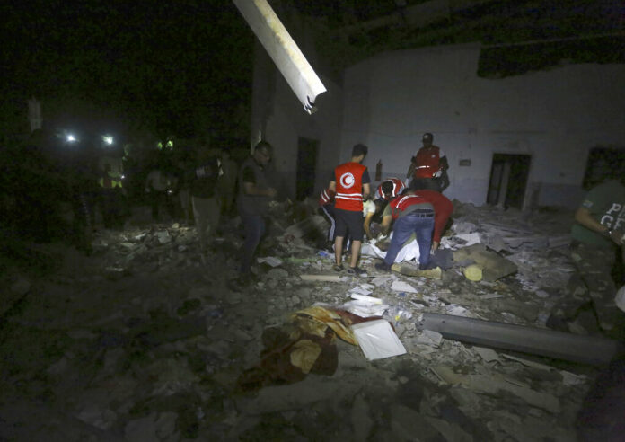 Libyan Red Crescent workers recover migrants bodies after an airstrike at a detention center in Tajoura, east of Tripoli Wednesday, July 3, 2019. An airstrike hit the detention center for migrants early Wednesday in the Libyan capital. Photo: Hazem Ahmed / AP