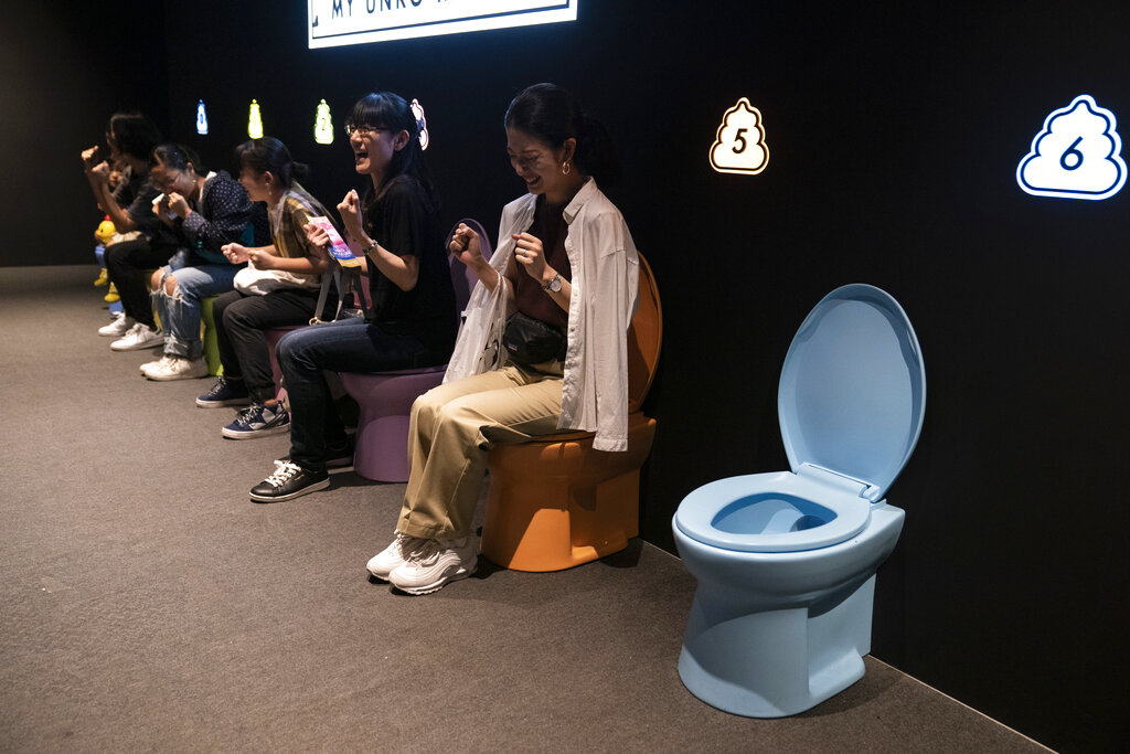 In this Monday, July 1, 2019, photo, visitors laugh as they jokingly motion to give a push while sitting on colorful toilet bowls at the Unko Museum in Yokohama, south of Tokyo. In a country known for its cult of cute, even poop is not an exception. A pop-up exhibition at the Unko Museum in the port city of Yokohama is all about unko, a Japanese word for poop. The poop installations there get their cutest makeovers. They come in the shape of soft cream, or cupcake toppings. Photo: Jae C. Hong / AP