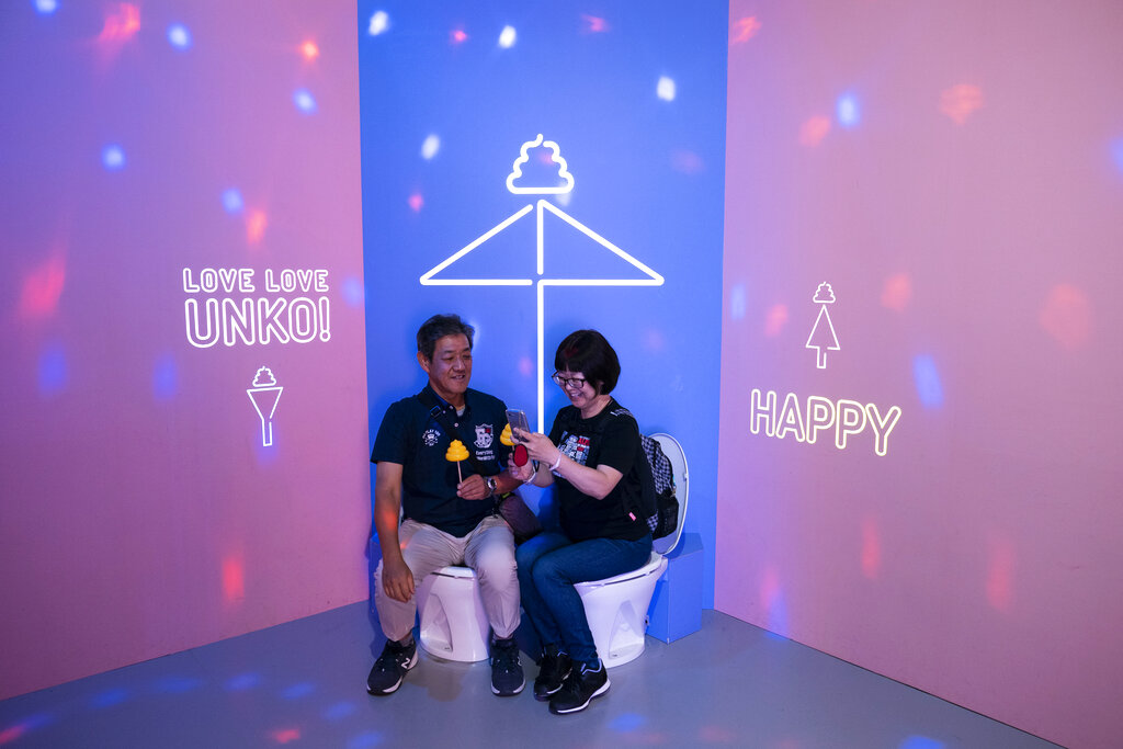 In this Tuesday, June 18, 2019, photo, a couple shares a light moment while sitting on toilet bowls at the Unko Museum in Yokohama, south of Tokyo. In a country known for its cult of cute, even poop is not an exception. A pop-up exhibition at the Unko Museum in the port city of Yokohama is all about unko, a Japanese word for poop. The poop installations there get their cutest makeovers. They come in the shape of soft cream, or cupcake toppings. Photo: Jae C. Hong / AP