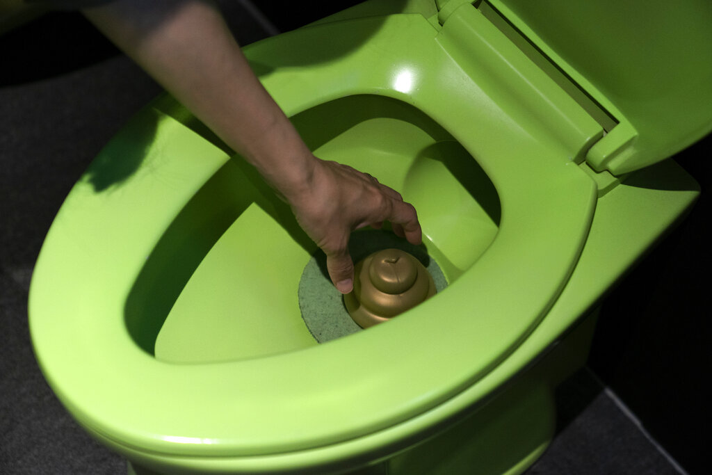 In this Tuesday, June 18, 2019, photo, a visitor reaches into a toilet bowl to pick up a toy poop at the Unko Museum in Yokohama, south of Tokyo. In a country known for its cult of cute, even poop is not an exception. A pop-up exhibition at the Unko Museum in the port city of Yokohama is all about unko, a Japanese word for poop. The poop installations there get their cutest makeovers. They come in the shape of soft cream, or cupcake toppings. Photo: Jae C. Hong / AP