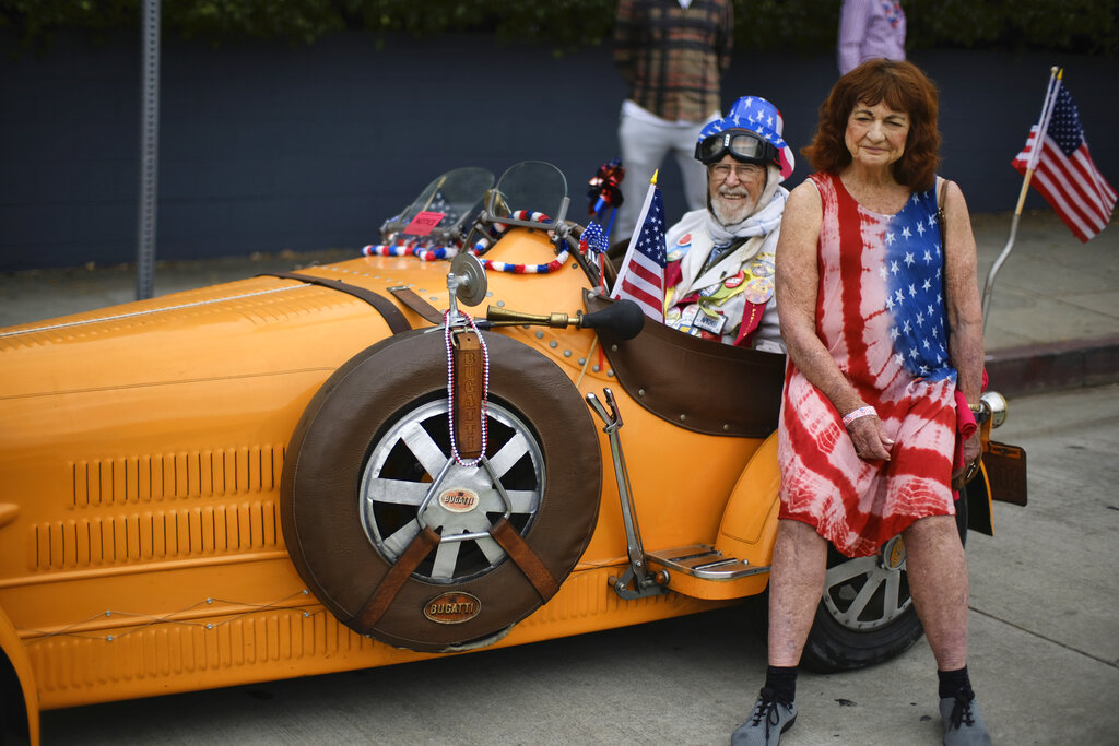 Karen Miller rests with Dr. Bernard Harris on his Bugatti classic car during the Santa Monica Fourth Of July Parade on Thursday, July 4, 2019 in Santa Monica, Calif. Photo: Richard Vogel / AP