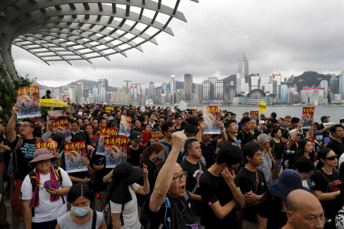 Protesters take part in a march in Hong Kong on Sunday, July 7, 2019. Protesters in Hong Kong are taking their message to visitors from mainland China on Sunday in a march to a high-speed rail station that connects to Guangdong city and other mainland destinations. Photo: Kin Cheung / AP