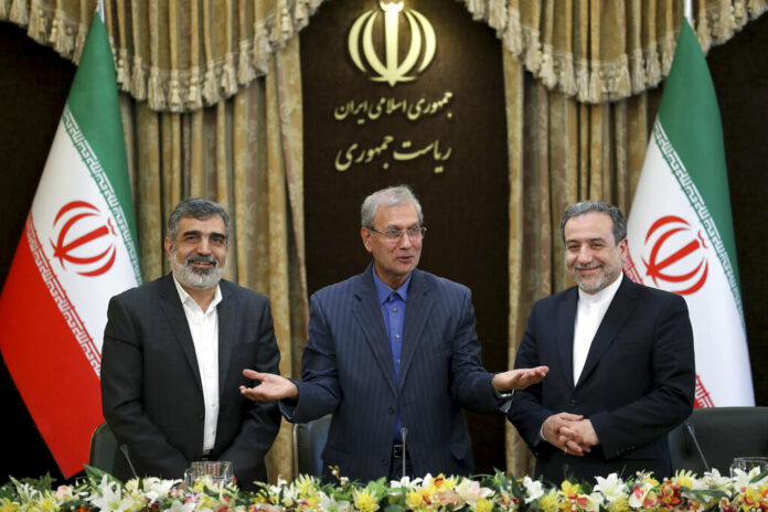 From left to right, spokesman for Iran's atomic agency Behrouz Kamalvandi, Iran's government spokesman Ali Rabiei and Iranian Deputy Foreign Minister Abbas Araghchi, attend a press briefing in Tehran, Iran, Sunday, July 7, 2019. The deputy foreign minister says that his nation considers the 2015 nuclear deal with world powers to be a 