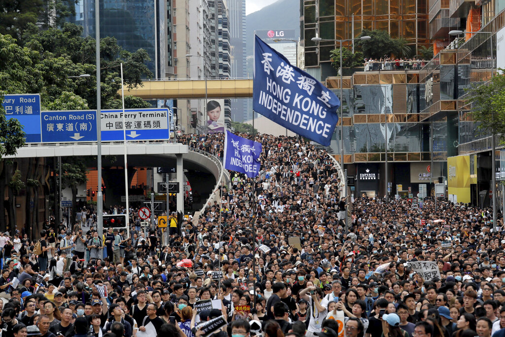 Protesters march with a flag calling for Hong Kong independence in Hong Kong on Sunday, July 7, 2019. Thousands of people, many wearing black shirts and some carrying British flags, were marching in Hong Kong on Sunday, targeting a mainland Chinese audience as a month-old protest movement showed no signs of abating. Photo: Kin Cheung / AP