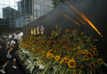 Parents of Dead Hong Kong Protester Urge Others to Carry On Attendees take part in a public memorial for Marco Leung, the 35-year-old man who fell to his death weeks ago after hanging a protest banner against an extradition bill, in Hong Kong, Thursday, July 11, 2019. The parents of Leung have urged young people to stay alive to continue their struggle. Photo: Kin Cheung / AP