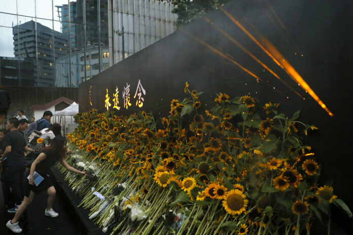 Attendees take part in a public memorial for Marco Leung, the 35-year-old man who fell to his death weeks ago after hanging a protest banner against an extradition bill, in Hong Kong, Thursday, July 11, 2019. The parents of Leung have urged young people to stay alive to continue their struggle. Photo: Kin Cheung / AP