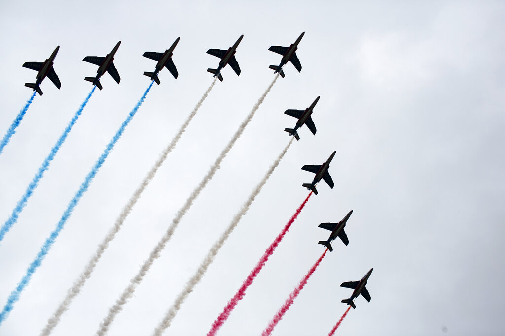 French Alpha jets of the Patrouille de France spray lines of smoke in the colors of the French flag over the Champs-Elysees during Bastille Day parade Sunday, July 14, 2019 near the Champs Elysees avenue in Paris. Photo: Rafael Yaghobzadeh / AP