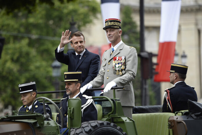 France's President Emmanuel Macron gestures in his command car next to French Armies Chief Staff General Francois Lecointre as they review troops before the start of the Bastille Day military parade down the Champs-Elysees avenue in Paris Sunday, July 14, 2019. French President Emmanuel Macron has overseen France's annual Bastille Day celebration, which this year showcased European defense cooperation. Photo: Eliot Blondet / POOL via AP