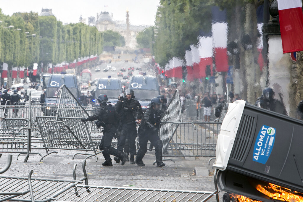 Riot police officers remove barricades that were uses as security barriers for Bastille Day parade on the Champs-Elysees avenue after scuffles with demonstrators, Sunday, July 14, 2019 in Paris. Photo: Rafael Yaghobzadeh / AP
