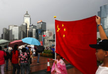 Hong Kong Police Seize Explosives as Rival Camps Rally Pro-China supporters raise a China national flag during a counter-rally in support of the police in Hong Kong Saturday, July 20, 2019. Police in Hong Kong have raided a homemade-explosives manufacturing lab ahead of another weekend of protests in the semi-autonomous Chinese territory. Photo: Vincent Yu / AP