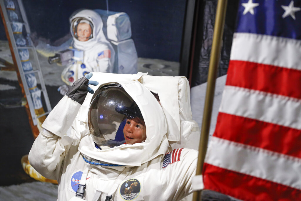 Visitors pose for photos beside a portrait of Neil Armstrong at the Armstrong Air and Space Museum as special events are underway for visitors commemorating the 50th anniversary of the first moon landing, Saturday, July 20, 2019, in Wapakoneta, Ohio. Photo: John Minchillo / AP