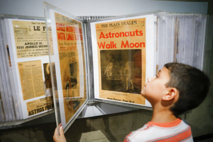 Ethan Reynolds browses a display of archival newspaper front pages announcing the first moon landing at the Armstrong Air and Space Museum as special events are underway for visitors commemorating the milestone's 50th anniversary, Saturday, July 20, 2019, in Wapakoneta, Ohio. Photo: John Minchillo / AP