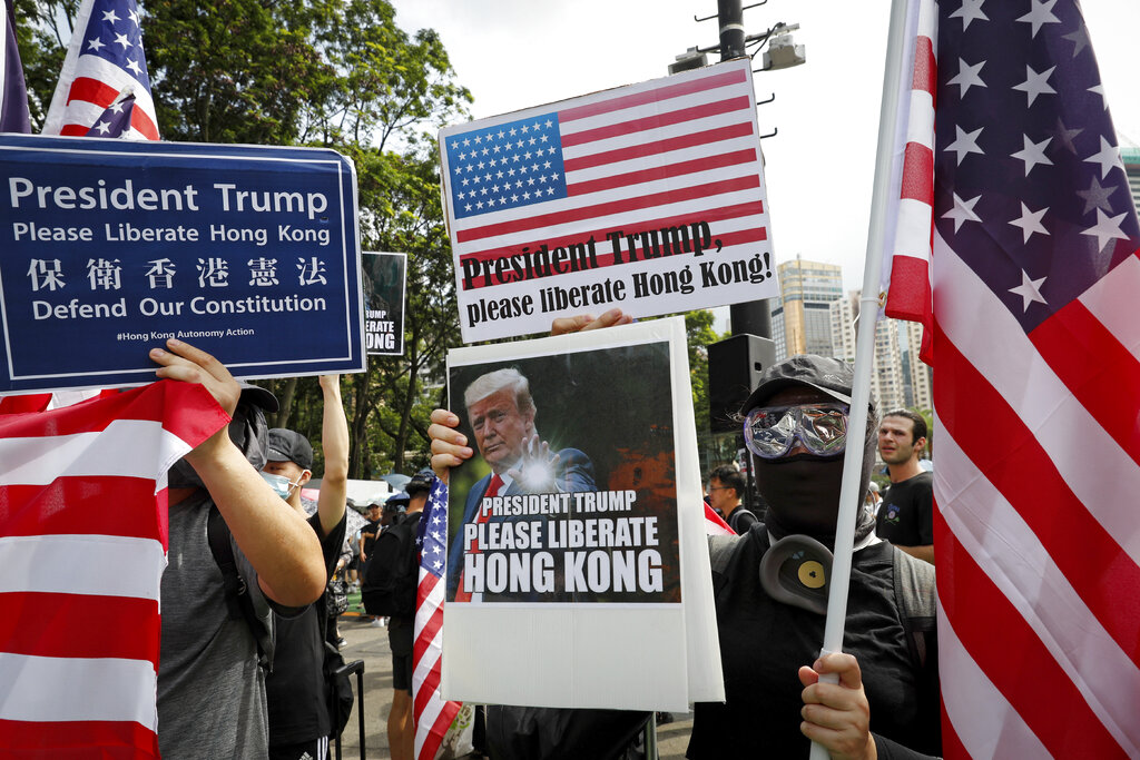 Protesters hold a placard featuring U.S. President Donald Trump and U.S. flags as they take part in a march at Victoria Park in Hong Kong, Sunday, July 21, 2019. Thousands of Hong Kong protesters marched from a public park to call for an independent investigation into police tactics. Photo: Vincent Yu / AP