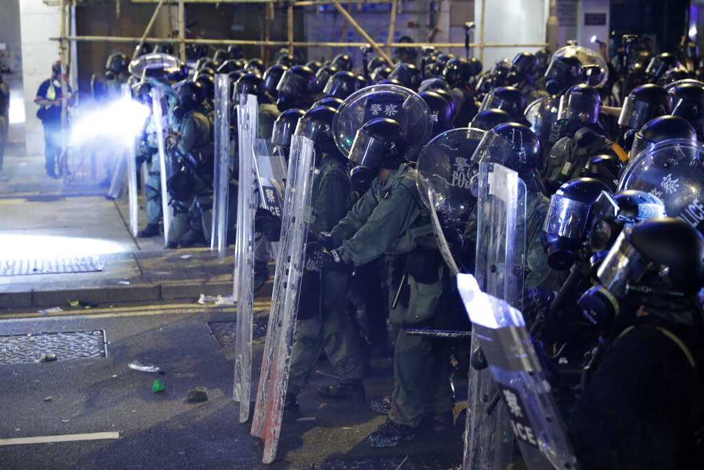 Riot police officer form up during a confrontation with protesters in Hong Kong on Sunday, July 21, 2019. Protesters in Hong Kong pressed on Sunday past the designated end point for a march in which tens of thousands repeated demands for direct elections in the Chinese territory and an independent investigation into police tactics used in previous demonstrations. Photo: Vincent Yu / AP