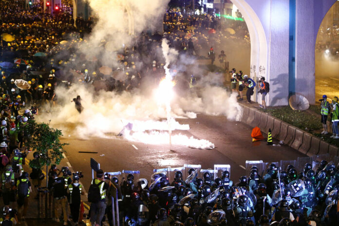 Protesters are engulfed by teargas during a confrontation with riot police in Hong Kong Sunday, July 21, 2019. Hong Kong police launched tear gas at protesters Sunday after a massive pro-democracy march continued late into the evening. The action was the latest confrontation between police and demonstrators who have taken to the streets to protest an extradition bill and call for electoral reforms in the Chinese territory. Photo: Lo Kwanho / HK01 via AP Protesters are engulfed by teargas during a confrontation with riot police in Hong Kong Sunday, July 21, 2019. Hong Kong police launched tear gas at protesters Sunday after a massive pro-democracy march continued late into the evening. The action was the latest confrontation between police and demonstrators who have taken to the streets to protest an extradition bill and call for electoral reforms in the Chinese territory. Photo: Lo Kwanho / HK01 via AP