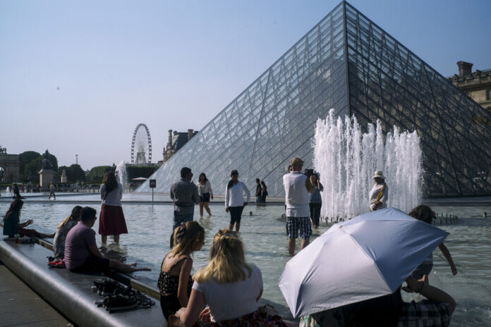 People cool off next to the fountains at Louvre Museum in Paris, France, Wednesday, July 24, 2019. Temperatures in Paris are forecast to reach 41 degrees C (86 F), on Thursday. Photo: Rafael Yaghobzadeh / AP