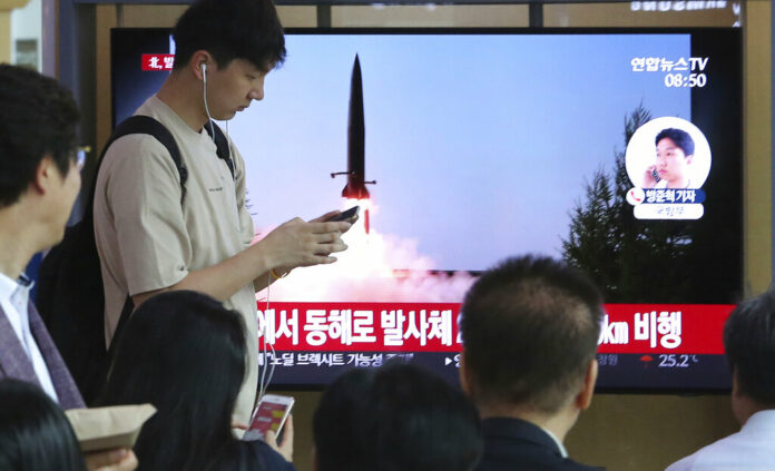 People watch a TV showing a file image of North Korea's missile launch during a news program at the Seoul Railway Station in Seoul, South Korea, Thursday, July 25, 2019. North Korea fired two unidentified projectiles into the sea on Thursday, South Korea's military said, the first launches in more than two months as North Korean and U.S. officials work to restart nuclear diplomacy. The signs read: 