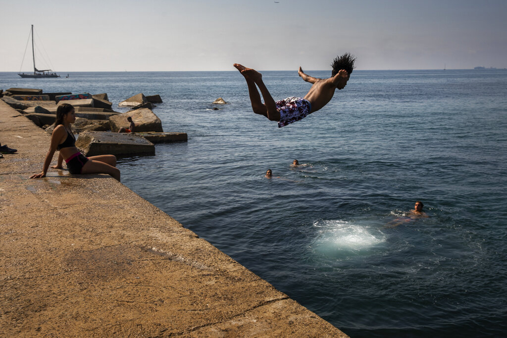 A boy jumps into the water at the beach in Barcelona, Spain, Thursday, July 25, 2019. Parts of Europe will likely see record-high temperatures on Thursday as much of the continent is trapped in a heat wave, the second in two months. Photo: Emilio Morenatti / AP