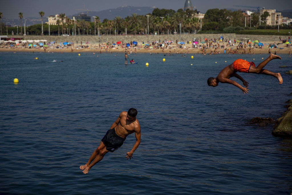 Men jump into the water at the beach in Barcelona, Spain, Thursday, July 25, 2019.  Parts of Europe will likely see record-high temperatures on Thursday as much of the continent is trapped in a heat wave, the second in two months. Photo: Emilio Morenatti / AP