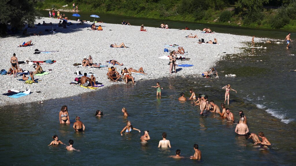 People enjoy the hot summer weather at the river Isar in Munich, Germany, Thursday, July 25, 2019. Photo: Matthias Schrader / AP