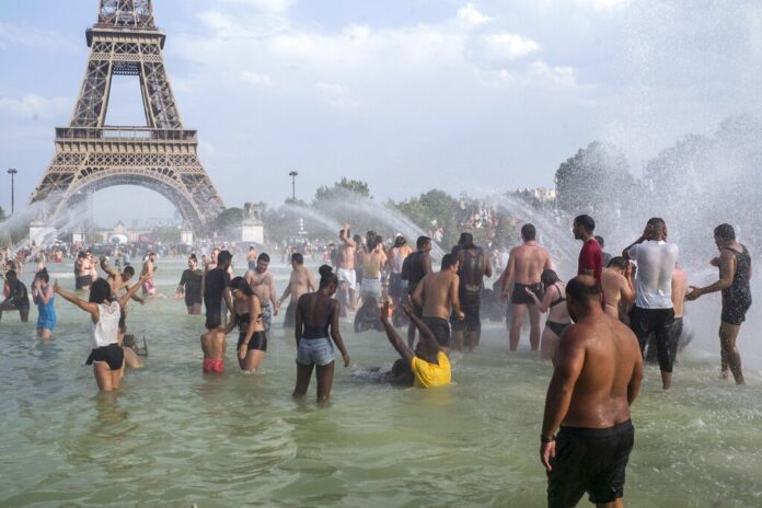 People cool down in the fountains of the Trocadero gardens in Paris, Thursday July 25, 2019, when a new all-time high temperature of 42.6 degrees Celsius (108.7 F) hit the French capital. in the background is the Eiffel Tower. Photo: Rafael Yaghobzadeh / AP