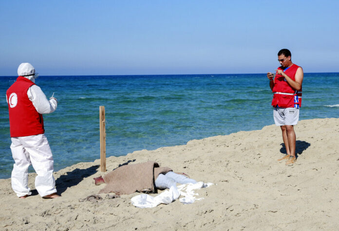 Libyan Red Crescent workers stand around a body of a drowned migrant near the city of Khoms, some 100 kilometers (60 miles) east of Tripoli, Libya, Friday, July 26, 2019. Photo: Hazem Ahmed / AP