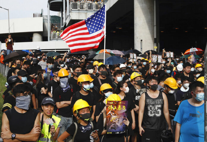 Protesters hold up a poster with the words 