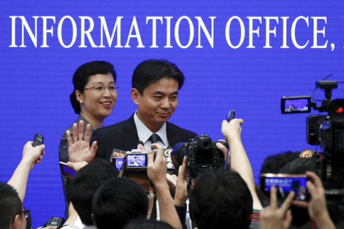 Yang Guang, spokesman of the Hong Kong and Macau Affairs Office of the State Council, gestures as reporters approach him after a press conference about the ongoing protests in Hong Kong, at the State Council Information Office in Beijing, Monday, July 29, 2019. Photo: Andy Wong / AP