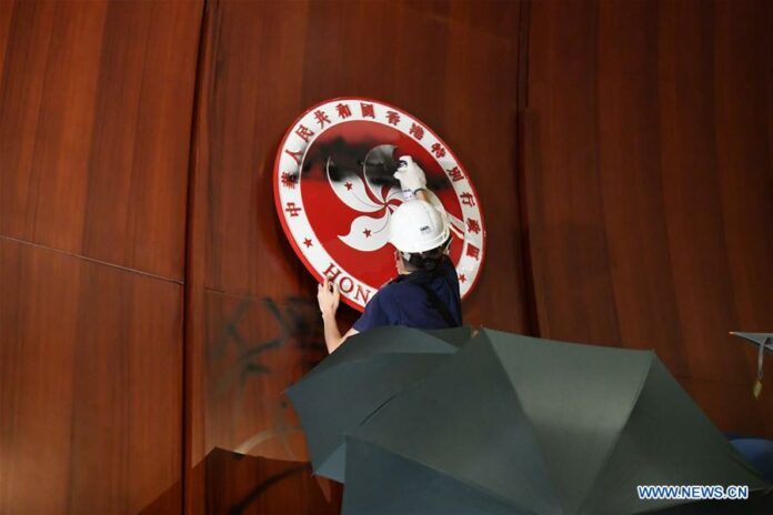 A protester vandalizes the regional emblem of Hong Kong Special Administrative Region after breaking and entering the Legislative Council building in Hong Kong, south China, July 1, 2019. Image: Xinhua.