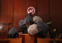 Die-Hard Hong Kong Protesters Defend Tactics as Unity Cracks In this July 1, 2019, file photo, protesters deface the Hong Kong logo at the Legislative Council to protest against the extradition bill in Hong Kong. Photo: Vincent Thian Yu, File / AP