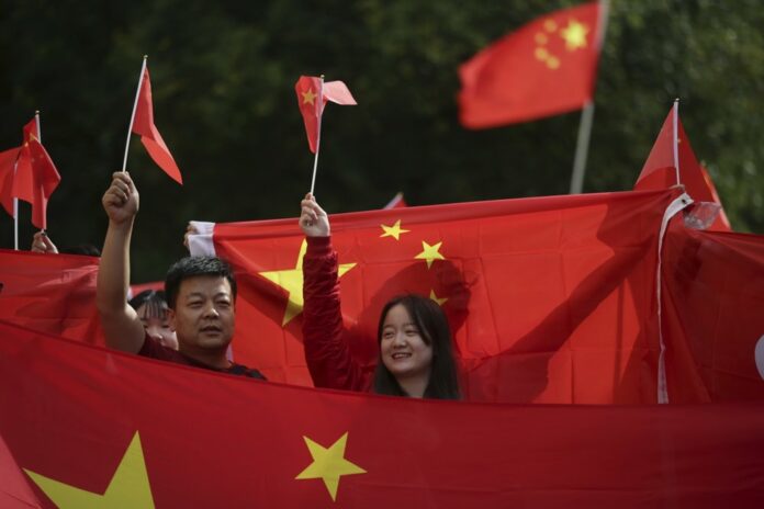 In this Aug. 17, 2019, file photo, pro-China counter-protesters hold Chinese flags during an anti-extradition rally for Hong Kong in Vancouver. Governments around the world are taking a cautious approach to responding to the protests roiling Hong Kong. With the notable exception of Taiwan, cautious comments from a handful of governments fall short of support for the demonstrators. (Darryl Dyck/The Canadian Press via AP, File)
