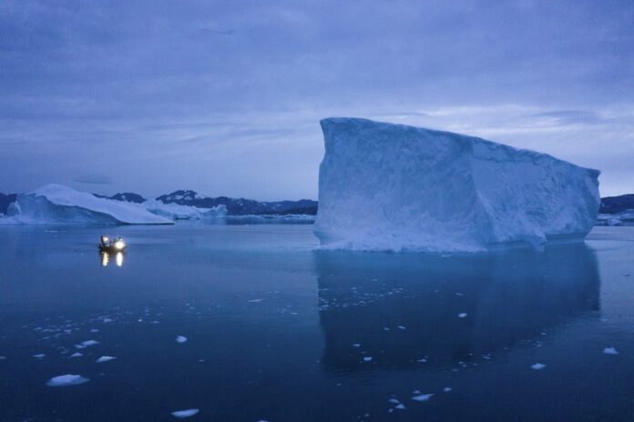 In this Aug. 15, 2019, file photo, a boat navigates at night next to large icebergs in eastern Greenland. As warmer temperatures cause the ice to retreat the Arctic region is taking on new geopolitical and economic importance, and not just the United States hopes to stake a claim, with Russia, China and others all wanting in. (AP Photo/Felipe Dana, File)