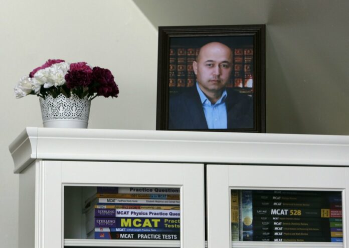 A portrait of Yalqun Rozi is seen atop a bookcase in his son and wife's apartment Thursday, April 18, 2019, in Philadelphia.(AP Photo/Jacqueline Larma)