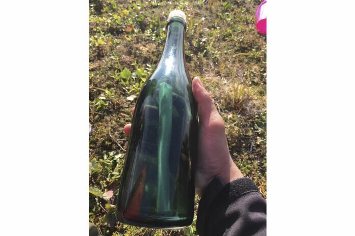 This undated photo provided by Tyler Ivanoff shows a bottle with a message that he found on the shores of western Alaska. (Tyler Ivanoff via AP)
