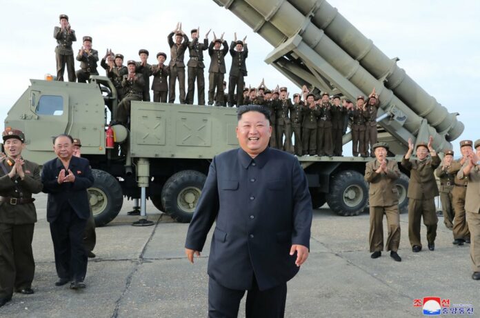 This Saturday, Aug. 24, 2019, photo provided Sunday, Aug. 25, by the North Korean government, shows North Korean leader Kim Jong Un, center, smiles after the test firing of an unspecified missile at an undisclosed location in North Korea. (Korean Central News Agency/Korea News Service via AP)