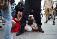 Moscow Couple Shaken but Defiant After Police Crackdown In this photo taken on Saturday, July 27, 2019, Inga Kudracheva screams as her boyfriend Boris Kantorovich lies atop her while police try to detain him during an unsanctioned protest in Moscow. Images of the young couple have been spread on social media. They say the crackdown by police has left them shaken but with their resolve strengthened. Photo: Denis Sinyakov / AP