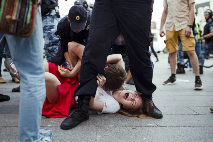 In this photo taken on Saturday, July 27, 2019, Inga Kudracheva screams as her boyfriend Boris Kantorovich lies atop her while police try to detain him during an unsanctioned protest in Moscow. Images of the young couple have been spread on social media. They say the crackdown by police has left them shaken but with their resolve strengthened. Photo: Denis Sinyakov / AP