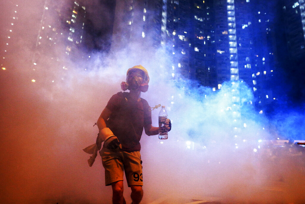 A protester stands in the midst of tear gas during confrontation with police in Hong Kong during the early hours of Sunday, Aug. 4, 2019. Hong Kong protesters ignored police warnings and streamed past the designated endpoint for a rally Saturday in the latest of a series of demonstrations targeting the government of the semi-autonomous Chinese territory. Photo: Elson Li / HK01 via AP