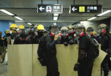 Hong Kong Protests Disrupt Flights, Subways as Strike Called Protesters with makeshift shields pass through a subway station on their way to a police station in Hong Kong on Sunday, Aug. 4, 2019. Photo: Kin Cheung / AP