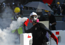 A Day of Striking Sows Chaos Across Hong Kong A protester throws back a tear gas canister in Hong Kong on Monday, Aug. 5, 2019. Droves of protesters filled public parks and squares in several Hong Kong districts on Monday in a general strike staged on a weekday to draw more attention to their demands that the semi-autonomous Chinese city's leader resign. Photo: Vincent Thian / AP