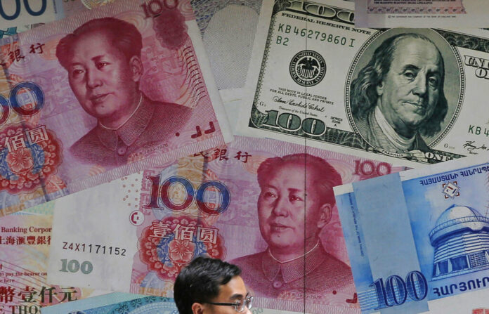 FILE - In this June 10, 2019, file photo, a man walks past a money exchange shop decorated with different banknotes at Central, a business district of Hong Kong. The U.S. Treasury Department labeled China a currency manipulator Monday, Aug. 5, after Beijing pushed down the value of its yuan in a dramatic escalation of the trade conflict between the world's two biggest economies. Photo: Kin Cheung / AP File
