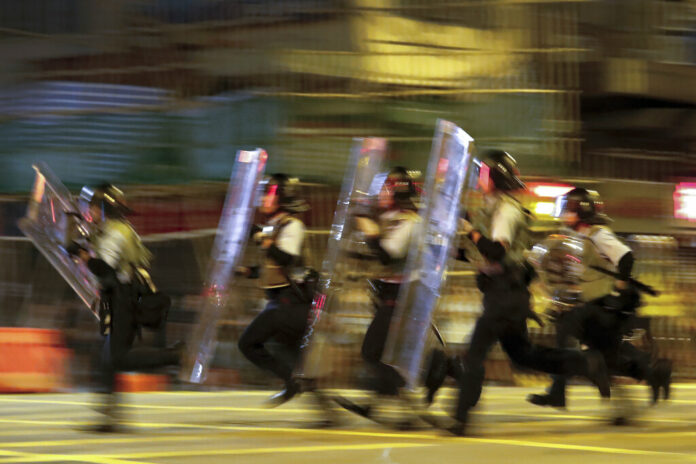 Policemen in riot gears move to disperse the residents and protesters at Sham Shui Po district in Hong Kong, Wednesday, Aug. 7, 2019. Protesters surrounded a Hong Kong police station to demand the release of a university student arrested for apparently buying laser pointers, sparking the latest confrontation in the Chinese city. Photo: Vincent Thian / AP
