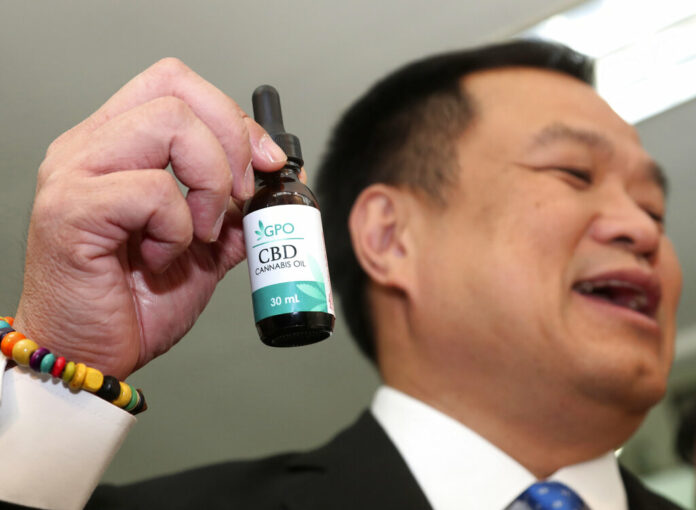 Thailand's Public Health Minister Anutin Chanvirakul shows off a bottle of extracted cannabis oil during a press conference at his ministry in Bangkok, Thailand, Wednesday, Aug. 7, 2019. The Health Ministry received its first batch of legal medical marijuana to be distributed in state-run hospitals. Photo: Sakchai Lalit / AP