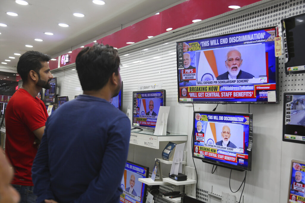 Indians watch Prime Minister Narendra Modi address the nation in a televised speech, in an electronics store in Jammu, India, Thursday, Aug. 8, 2019. Modi says a federally-ruled Indian portion of Kashmir will help end decades-old separatism incited by archrival Pakistan. Describing changes in Kashmir as historic, Modi assures Kashmiri people that the situation in the region will soon become normal. Photo: Channi Anand / AP