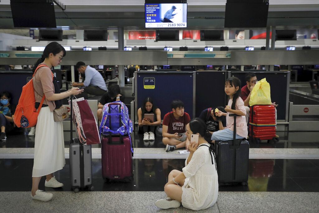 Travelers gather at the closed check-in counters as protesters stage a protest at the Hong Kong International Airport, Monday, Aug. 12, 2019. Photo: Kin Cheung / AP